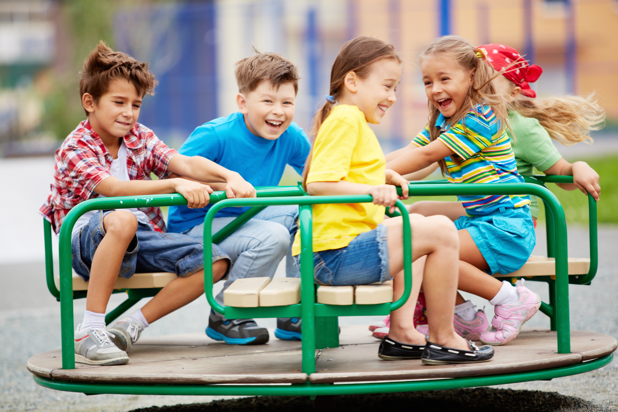 Children playing on merry-go-round experiencing the thrill of active outdoor play